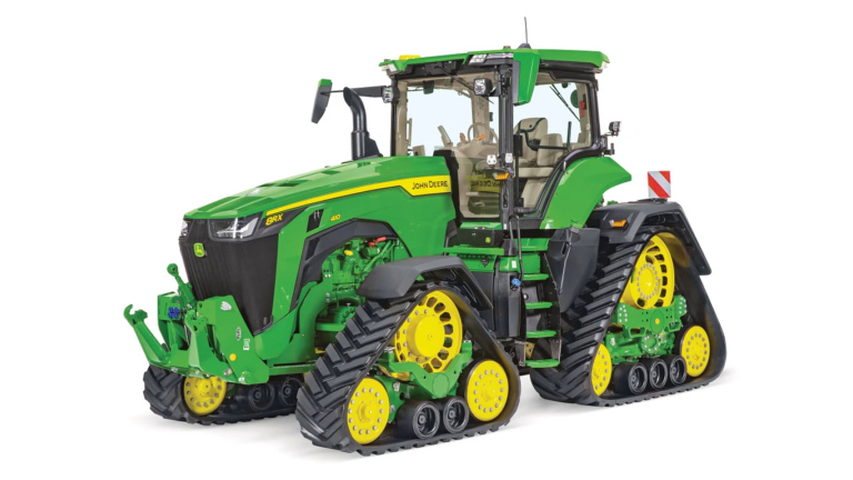Traktor John Deere 8RX s štirimi gosenicami s sprednjega desne strani na belem ozadju z neodvisnimi gosenicami in popolnoma zaprto kabino.